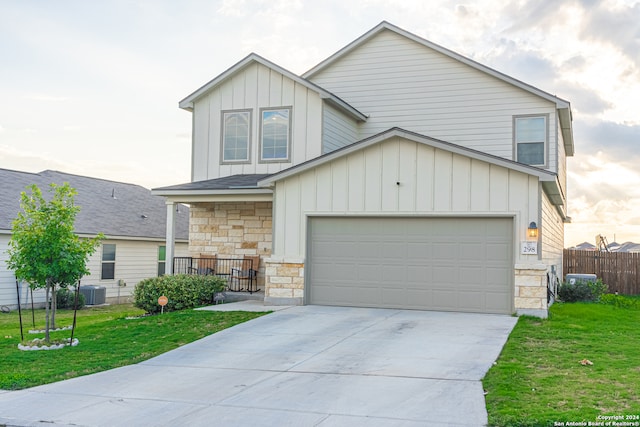 view of front of house featuring cooling unit, a front yard, and a garage