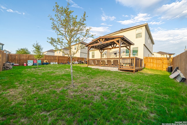 back of house with a gazebo, a deck, and a yard