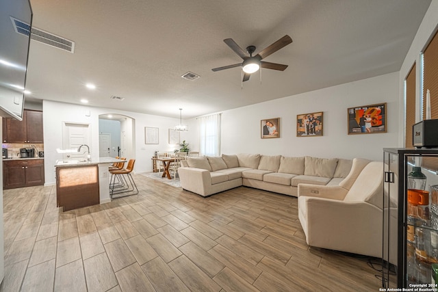 living room featuring light wood-type flooring and ceiling fan