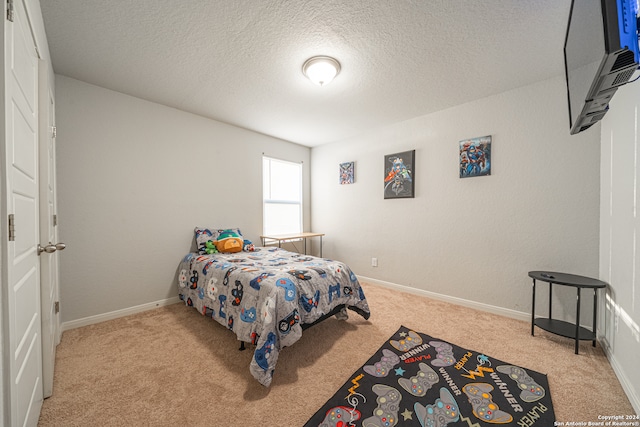 bedroom with a textured ceiling and light carpet