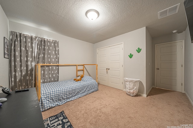 bedroom featuring a textured ceiling and carpet flooring