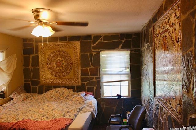 bedroom with ceiling fan and a textured ceiling