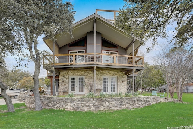 rear view of house with a balcony and a yard