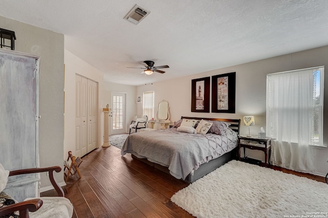 bedroom featuring a closet, a textured ceiling, ceiling fan, and dark hardwood / wood-style flooring