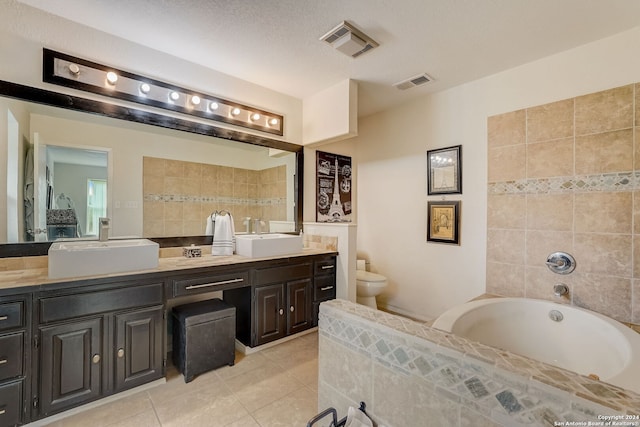 bathroom featuring a bathing tub, a textured ceiling, tile patterned floors, vanity, and toilet