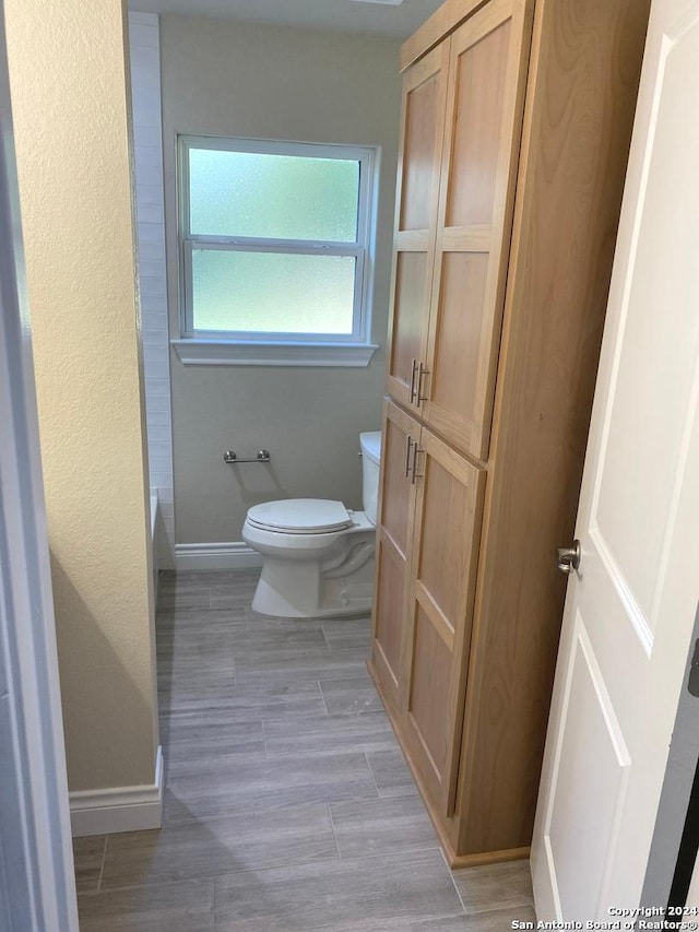 bathroom featuring hardwood / wood-style floors and toilet