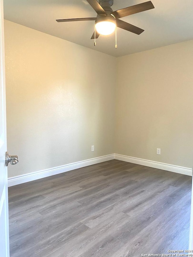 spare room with ceiling fan and dark hardwood / wood-style flooring