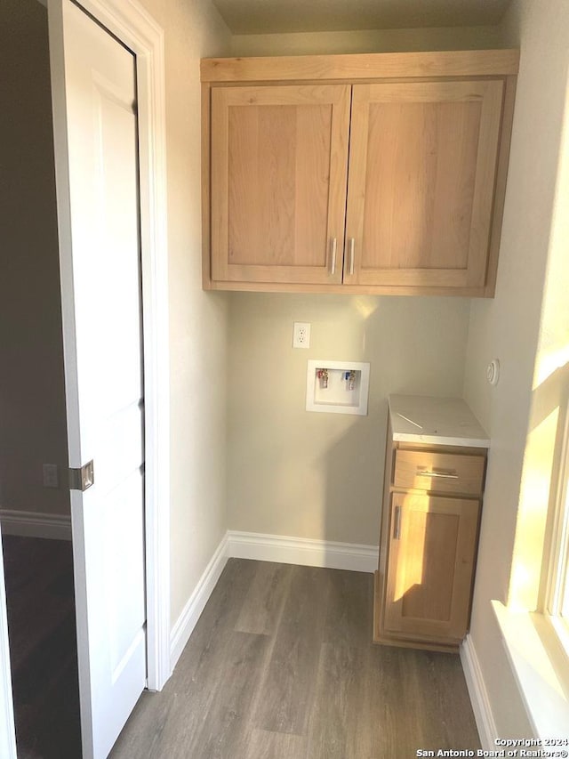 washroom with cabinets, hookup for a washing machine, and dark wood-type flooring