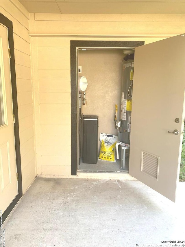 exterior space featuring wood walls and water heater