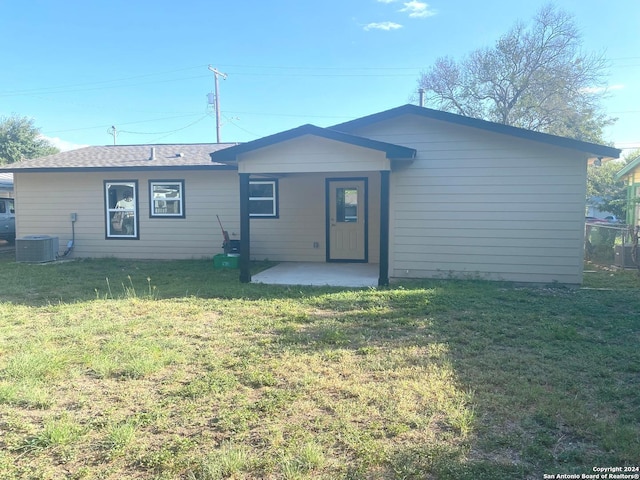 back of property featuring central air condition unit and a lawn