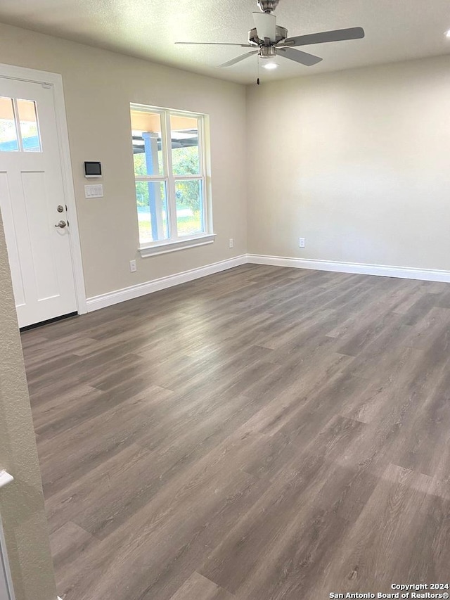 interior space with dark wood-type flooring, ceiling fan, and a textured ceiling