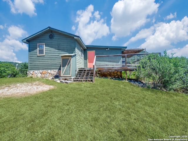 back of property featuring a lawn and a deck