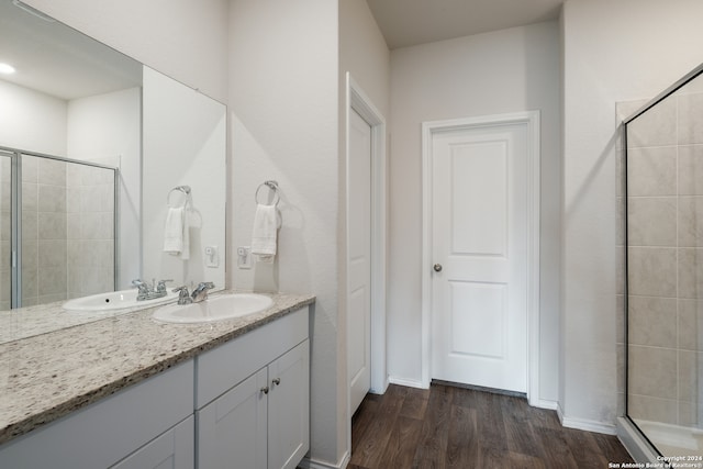 bathroom with vanity, hardwood / wood-style floors, and a shower with door