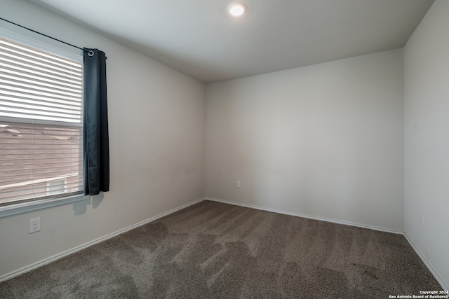 empty room featuring dark carpet