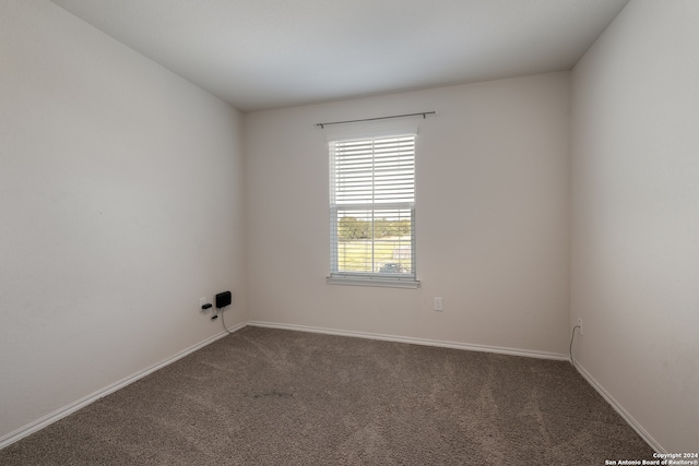 unfurnished room with dark carpet