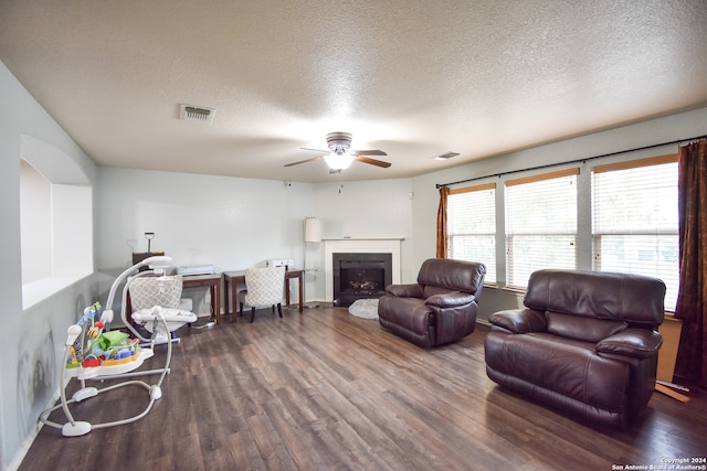 living room featuring a textured ceiling, dark hardwood / wood-style flooring, and ceiling fan