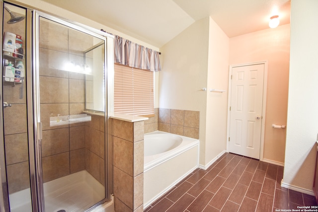 bathroom with independent shower and bath and vaulted ceiling