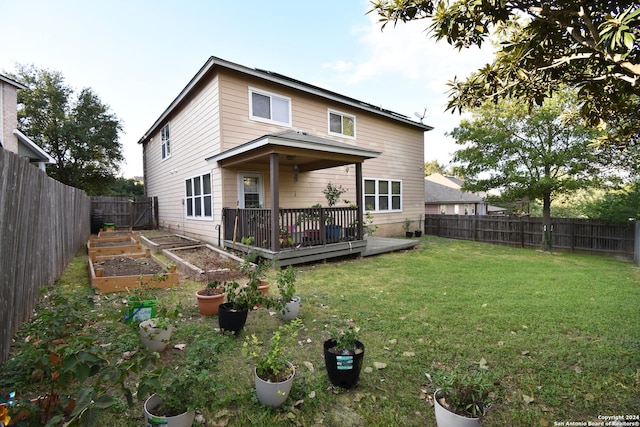 rear view of house featuring a wooden deck and a lawn