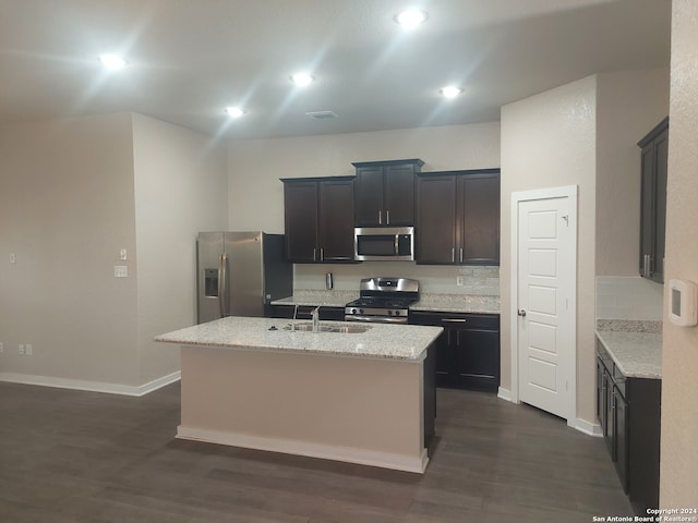 kitchen with dark hardwood / wood-style floors, sink, stainless steel appliances, and a kitchen island with sink