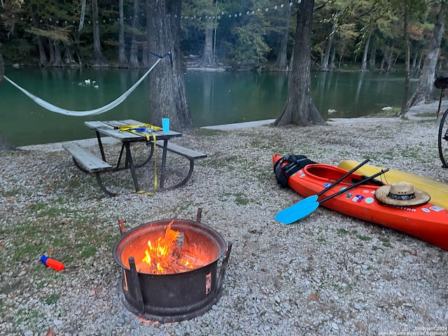 view of home's community featuring a fire pit and a water view