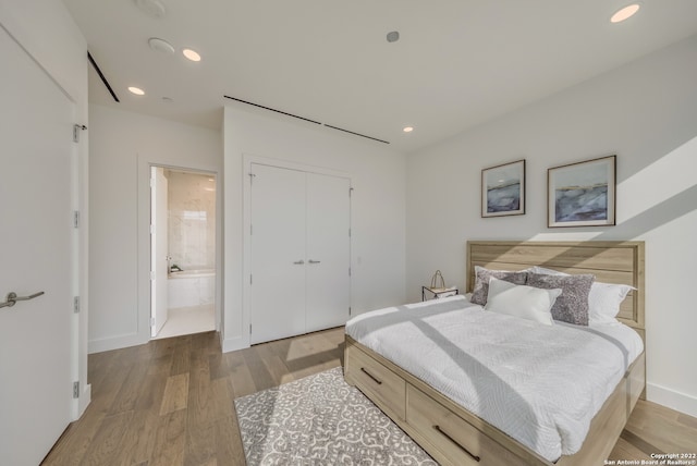 bedroom with connected bathroom, a closet, and hardwood / wood-style floors