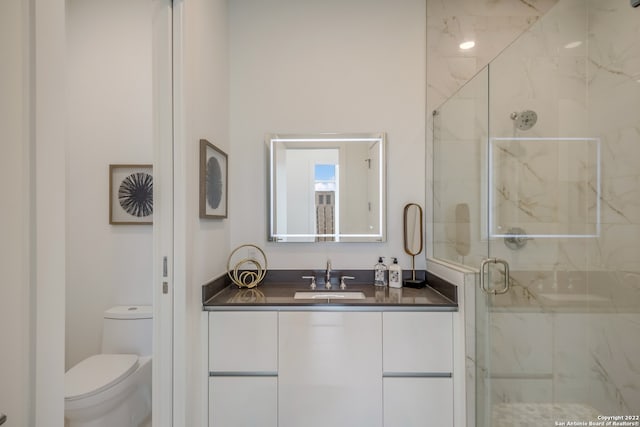 bathroom with an enclosed shower, vanity, and toilet