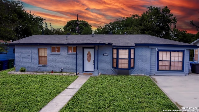 single story home featuring a lawn