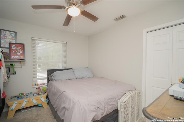 carpeted bedroom featuring ceiling fan and a closet