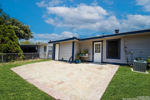 back of house featuring a yard, central air condition unit, and a patio area