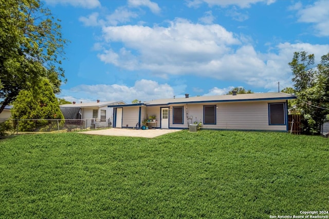 back of house featuring central AC unit, a patio area, and a yard