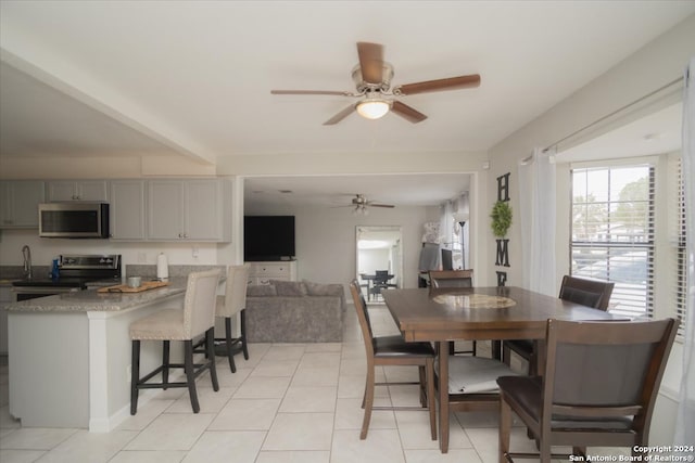 dining room with ceiling fan, light tile patterned floors, and sink