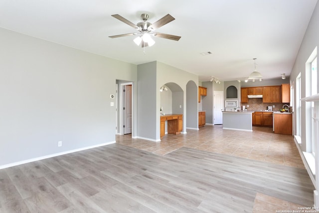 unfurnished living room featuring light hardwood / wood-style floors and ceiling fan