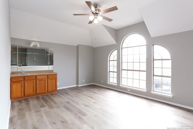 unfurnished living room featuring light hardwood / wood-style floors, ceiling fan, and sink