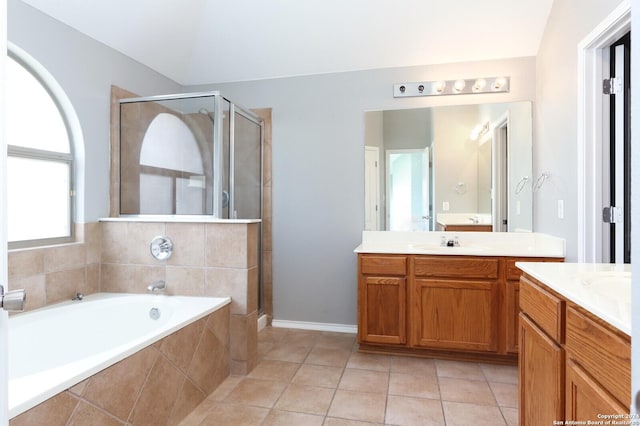 bathroom with tile patterned floors, vanity, separate shower and tub, and vaulted ceiling