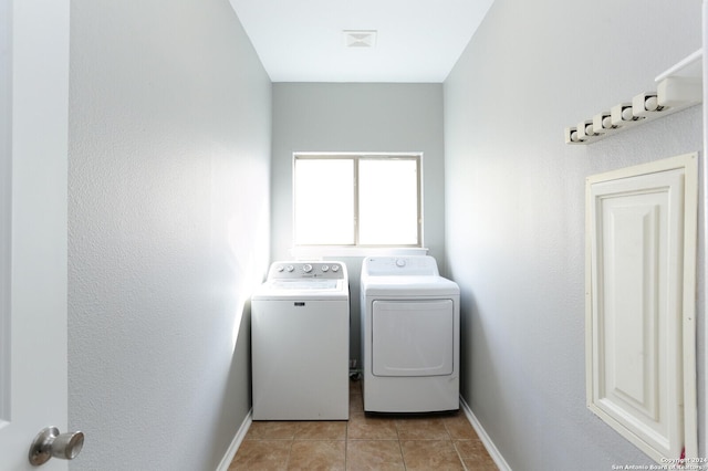 clothes washing area featuring light tile patterned flooring and independent washer and dryer