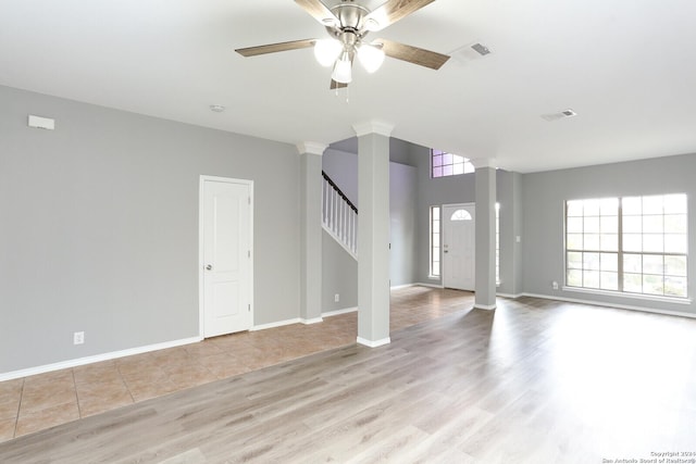 unfurnished living room with decorative columns, ceiling fan, and light hardwood / wood-style flooring