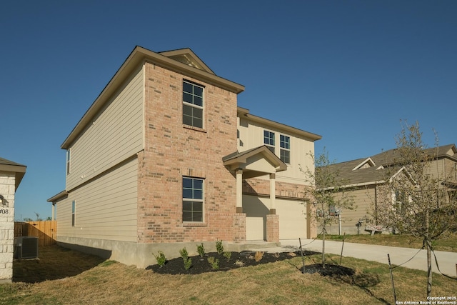 rear view of property with driveway, an attached garage, brick siding, central AC, and fence