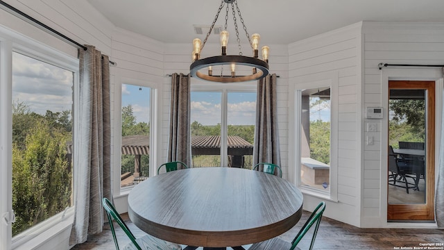 interior space featuring an inviting chandelier, wooden walls, and dark hardwood / wood-style floors