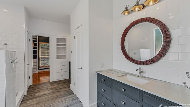 bathroom with vanity, hardwood / wood-style floors, and decorative backsplash