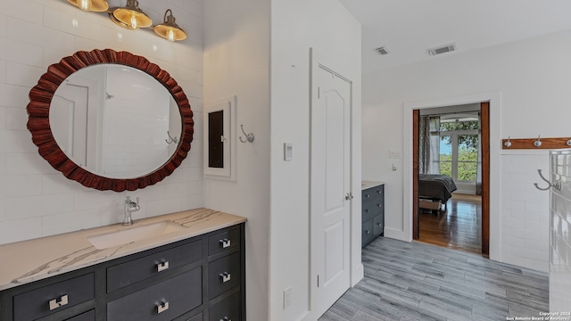 hall featuring tile walls, sink, and light hardwood / wood-style flooring