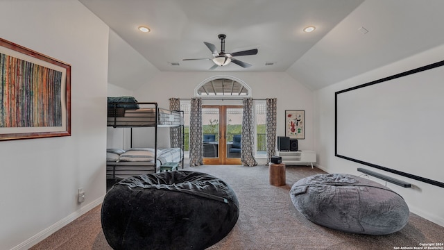 carpeted home theater room with ceiling fan, french doors, and vaulted ceiling