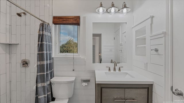 bathroom featuring walk in shower, vanity, tile walls, and toilet