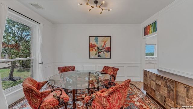 dining area featuring ornamental molding, hardwood / wood-style floors, and a chandelier