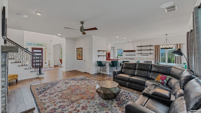 living room featuring ceiling fan with notable chandelier and hardwood / wood-style floors