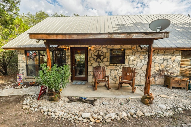 1177 River Rd, Concan, TX 78801 - back of house with stone siding, a standing seam roof, and metal roof