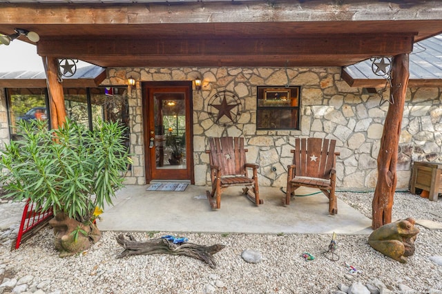 1177 River Rd, Concan, TX 78801 - doorway to property featuring stone siding and covered porch