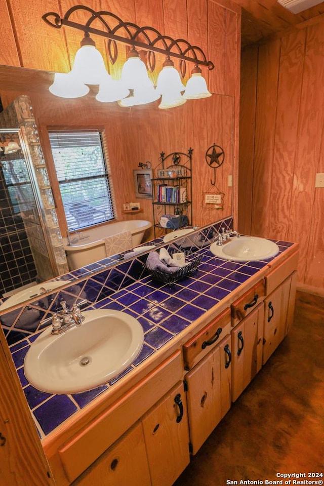 1177 River Rd, Concan, TX 78801 - bathroom with double vanity, a shower stall, a bath, and wood walls