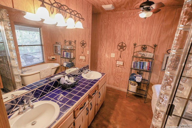 bathroom featuring wooden walls, ceiling fan, a washtub, and vanity