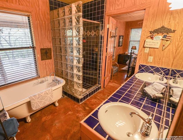 1177 River Rd, Concan, TX 78801 - bathroom with a shower stall, a freestanding bath, wooden walls, double vanity, and concrete floors