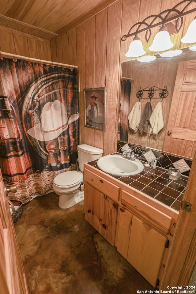 bathroom featuring toilet, wooden ceiling, wooden walls, vanity, and a shower with curtain